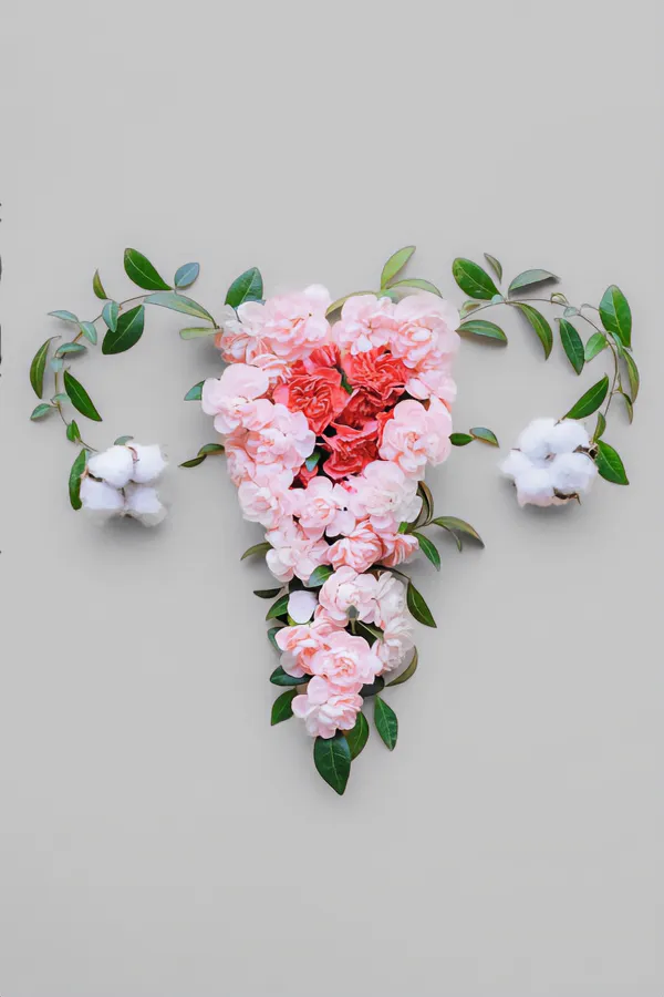 Endometriosis-Treatment Flowers on a gray background, arranged in the shape of the female reproductive system, representing Endometriosis treatment from Raving Health in Virginia Beach.