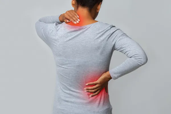 Fibromyalgia-Clinic An image from behind of a woman suffering from Fibromyalgia holding her hands on her neck and lower back. Get fibromyalgia care from Raving Health in Virginia Beach.