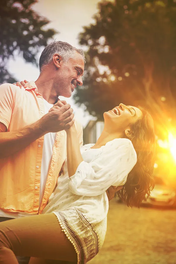 A middle-aged couple dance outside at sunset. Get an InBody Body Compostion Scan from Raving Health in Virginia Beach