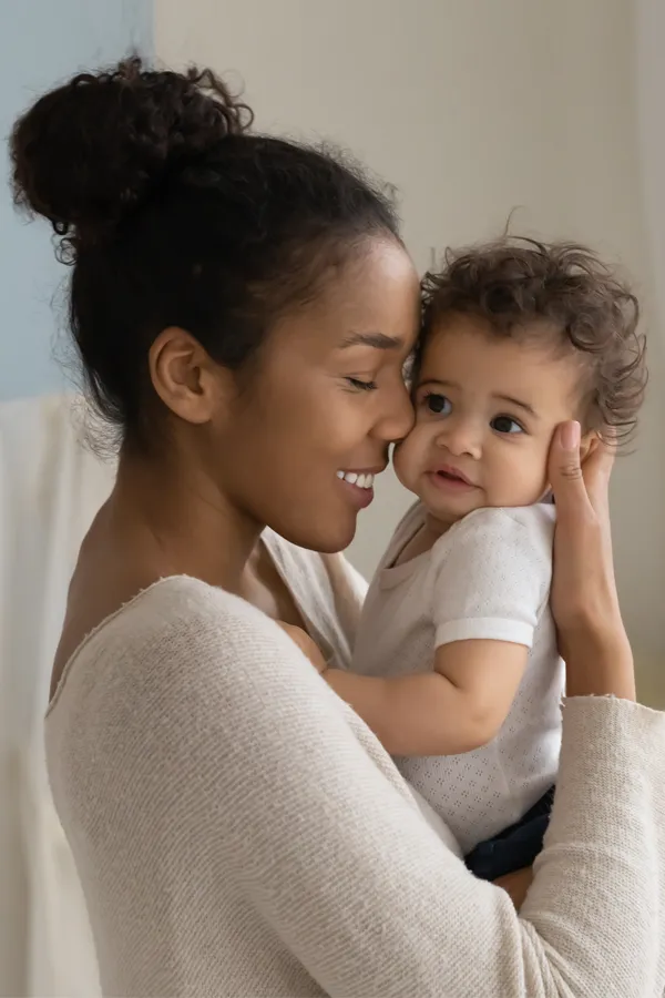 Postpartum-Hormone-Imbalance-Treatment A black woman happily touches her forehead to her infant's head. Get treatment for postpartum hormone imbalance from Raving Health in Virginia Beach.